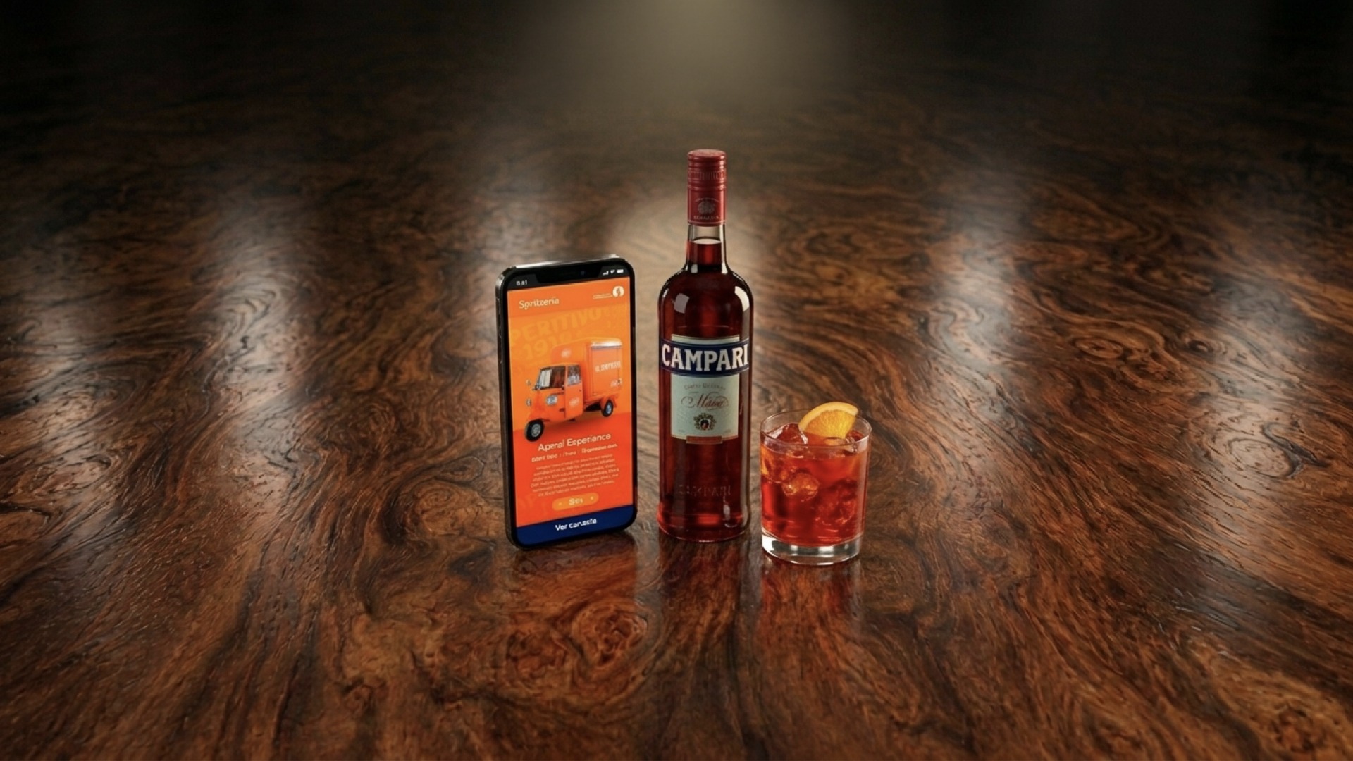 Campari bottle and Negroni beside a phone showing the La Spritzería delivery tuk-tuk booking app for Aperol