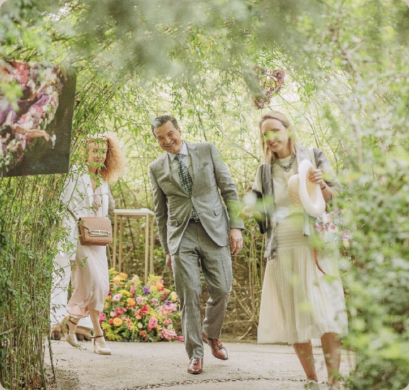 Guests walking through a floral garden arch at the Aqua Allegoria relaunch