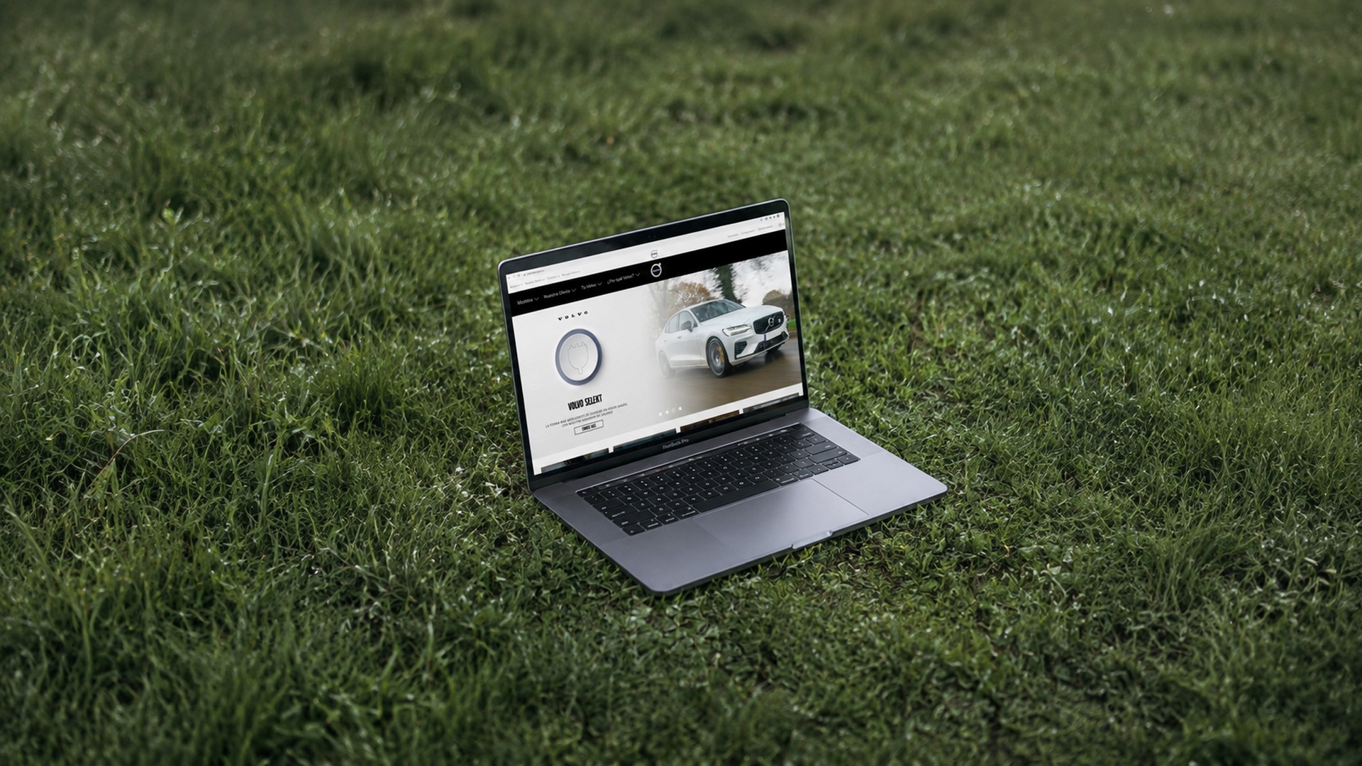 Laptop mockup of the Volvo Select certified pre-owned website page on grass